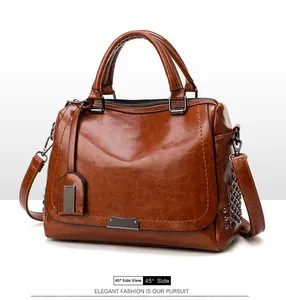Détail macro du sac à main vintage en cuir huilé marron avec rivets et métal poli