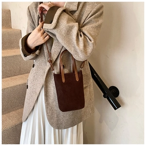Close-up of a vintage dark brown faux suede mini tote bag with leather handles and strap