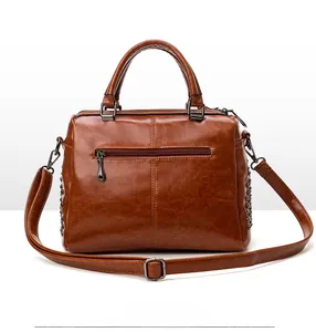 Vue arrière du sac vintage marron à rivets avec poche zippée et bandoulière amovible