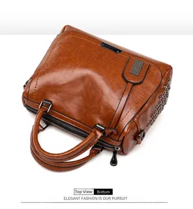 Détail d'un sac à main marron vintage avec des rivets métalliques et un style industriel