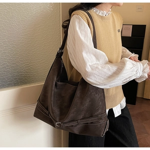 Vista dettagliata della borsa tote grande caffè scuro con fibbie e cinturini laterali