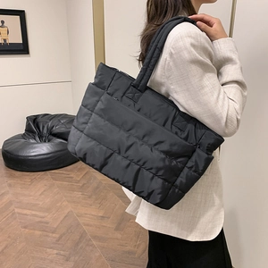 Large black quilted puffer tote bag made of waterproof nylon for daily commuting use