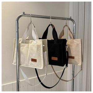 Detail showing high-quality corduroy fabric texture and leather 'FASHION' label on tote bag