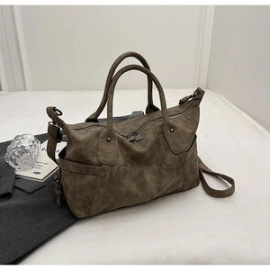 Detailed view of the olive green tote bag featuring thick handles and a side zipper pocket