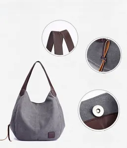 Detail view of gray canvas tote bag featuring leather handles and magnetic snap closure