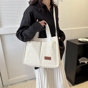 Minimalist beige corduroy tote bag with double front pockets and fashion leather label