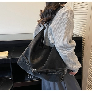 Dettaglio della borsa hobo in pelle scamosciata opaca con fibbie e cuciture bianche