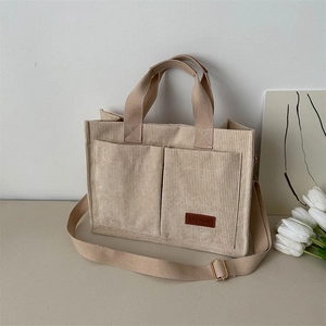 Fashionable tan corduroy tote bag with dual front pockets and adjustable shoulder strap