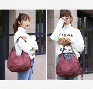 Deep burgundy canvas tote bag with brown leather straps shown on a model for size