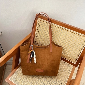 Vintage brown suede shoulder tote bag with decorative wooden beads and a sleek handle