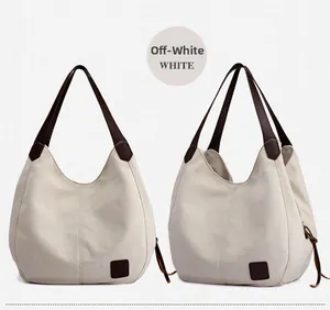 Detail view of off-white canvas tote bag with brown leather handles and sturdy base