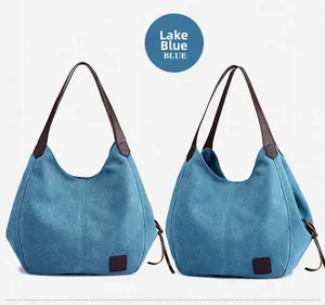Detail view showing lake blue canvas fabric and brown leather straps of the tote bag