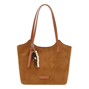 Brown suede tote bag with leather straps and decorative beads on white background