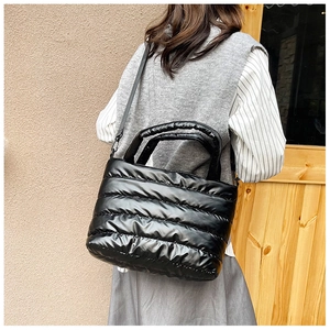 Macro-opname van zwarte gewatteerde tote bag met zachte nylon stoffen textuur