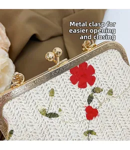 Détail du fermoir vintage doré sur le sac à main en paille brodé de fleurs rouges