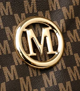 Close-up of golden circular metal M logo on brown monogram tote bag with print detail