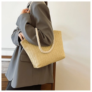 Détail du sac cabas en paille tressée avec anses en corde blanche sur un mannequin