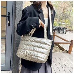 Detail van champagne goud gewatteerde tote bag met afneembare brede schouderriem