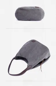 Detailed bottom and side view of grey canvas tote bag with dark brown leather accents