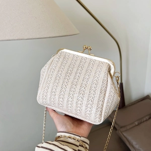 Bolso de mano trenzado en color crema con cadena dorada y cierre metálico vintage