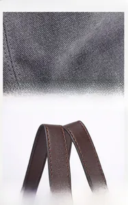 Detailed macro view showing the heavy-duty canvas texture and fine leather handle stitching