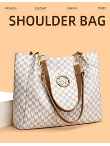 Detail of metal M logo and grey monogram print on off-white tote bag surface