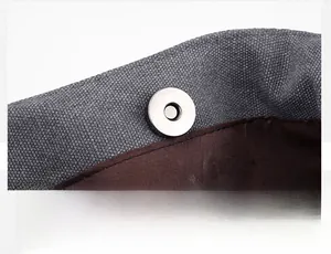 Detail of silver magnetic metal snap button on high-density gray canvas handbag