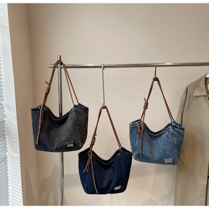 Detailed close-up of three washed denim tote bags featuring vintage frayed edges and knotted straps