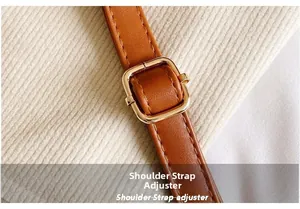 Macro shot of adjustable leather shoulder strap with a golden metal buckle and stitching
