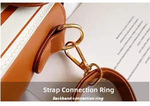 Close-up of golden metal D-ring and swivel hook on brown and white striped PU leather bag