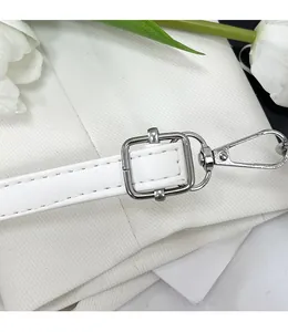 Détail de la bandoulière en cuir blanc réglable avec boucle en métal argenté de qualité