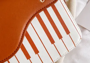 Close-up of brown leather bag featuring an artistic piano key pattern and fine stitching