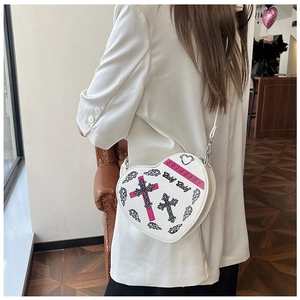 Détail du sac à bandoulière en forme de cœur en similicuir blanc avec motifs croix