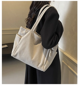 Dettaglio borsa tote in velluto a coste beige con texture a coste e tasca laterale
