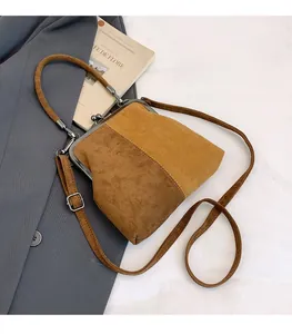 Gros plan détaillé du sac rétro en daim avec fermoir métallique et design bicolore