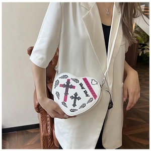 Détail du sac en cuir blanc en forme de cœur avec imprimé croix et texte Baby Baby