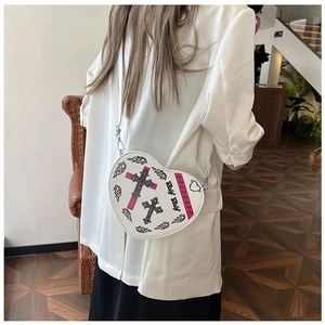 Détail du sac à bandoulière en forme de cœur avec imprimé gothique et chaîne argent