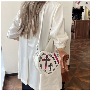 Vue latérale du mannequin portant un sac à bandoulière blanc en forme de cœur