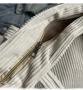 Dettaglio della cerniera in metallo e tessuto a coste su borsa tote grigia