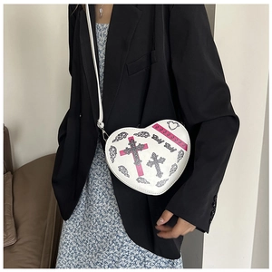 Vue détaillée du sac bandoulière en forme de cœur avec imprimé gothique porté par un mannequin