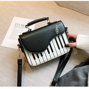 Detail of creative piano key design bag featuring musical note hardware and bicolour leather