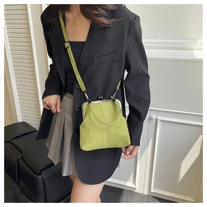 Detail shot of green suede shell crossbody bag with silver metal frame and strap
