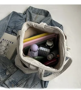 Vista dall'alto della borsa tote in velluto a coste beige con ampio spazio per oggetti