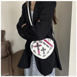 Détail du sac à bandoulière blanc en forme de cœur avec croix gothique et imprimé
