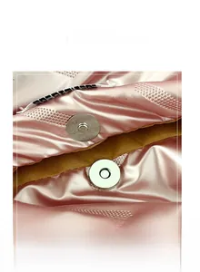 Détail du fermoir magnétique en argent sur le sac fourre-tout en satin rose matelassé