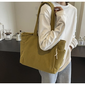 Vista dettagliata della borsa tote in velluto a coste gialla con tasche laterali e texture
