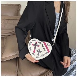 Détail du sac à bandoulière blanc en forme de cœur avec imprimé gothique chic