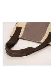 Detail view of reinforced canvas tote handles with contrast leather comfort grip