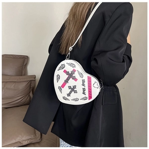 Détail du sac bandoulière blanc en forme de cœur avec imprimés punk Y2K et bandoulière