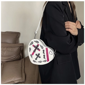 Vue détaillée du sac à bandoulière blanc en forme de cœur avec imprimés gothiques Y2K